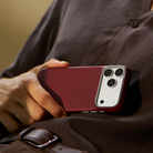 iPhone 18 Pro Max Karbon Kılıf Edge Burgundy - elde tutulan kılıf, kahverengi ceket önünde