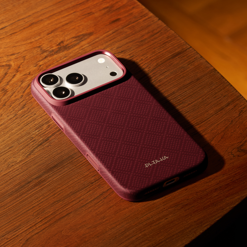 iPhone 18 Pro Max Karbon Kılıf Summa Burgundy - ahşap masa üzerinde kılıflı telefon